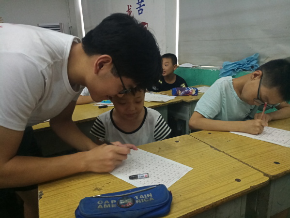 志愿者指导小孩子们写硬笔书法 志愿者指导小孩子们写硬笔书法