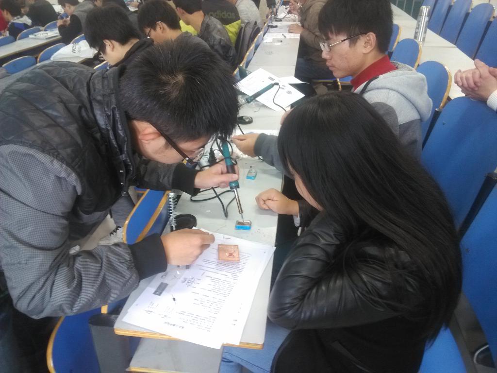 会长张文豪正在教会员如何焊接电路